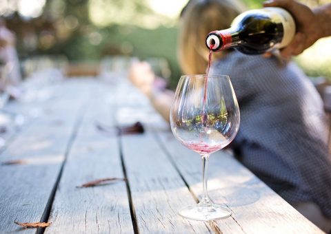 rotwein wird in ein glas gegosssen